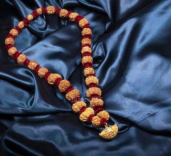 Rudraksha mala laid out on blue silk