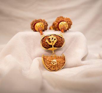 Rudraksha beads with a gold pendant on white silk